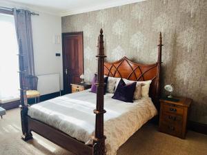 a bedroom with a large bed with a wooden frame at Abbotsleigh of Whitby in Whitby