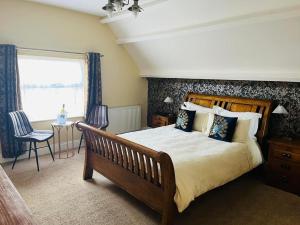 a bedroom with a large bed and a table at Abbotsleigh of Whitby in Whitby