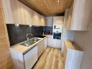 uma cozinha com armários de madeira e um lavatório em Appartement Les Gets, 2 pièces, 4 personnes - FR-1-598-136 em Les Gets