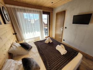 uma cama grande num quarto com uma janela grande em Appartement Les Gets, 2 pièces, 4 personnes - FR-1-598-136 em Les Gets