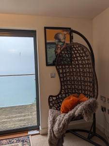 a room with a chair with a mirror and a window at Panoramic sea views, sleeps 4, Torquay in Torquay