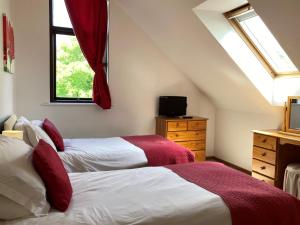a attic bedroom with two beds and a window at Water Mill Vacations Badgers Oak - Pet Friendly in Newport