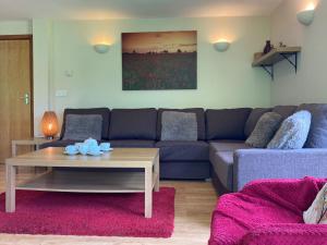 a living room with a couch and a table at Water Mill Vacations Badgers Oak in Newport