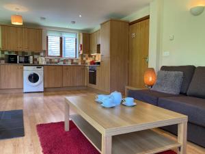 a living room with a table and a couch at Water Mill Vacations Badgers Oak in Newport +39 photos