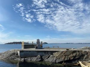 un quai avec un phare sur une étendue d'eau dans l'établissement House by sea - Bergen, Norway. Free boat., à Askøy
