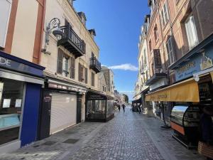 an empty street with buildings and shops on a city at La plage logement de tourisme meublé - 3 étoiles in Villers-sur-Mer