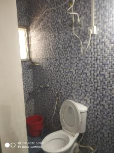 a small bathroom with a toilet and a shower at Bethel Guesthouse Panaji in Panaji