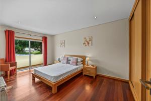a bedroom with a bed and a window at Tranquil Hideaway Olhos de Agua in Faro +41 photos
