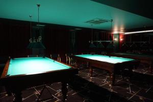 two pool tables in a dark room with ping pong balls at Villa Malva in Łomianki