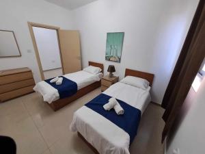 a hotel room with two beds with towels on them at St Julians Sliema 3 minutes walk from promenade 3 bedroom apartment in Sliema