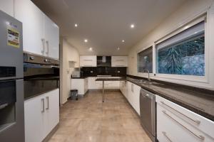 a kitchen with white cabinets and a large window at Zyra villa with pool and waterfall in New Cairo in Cairo