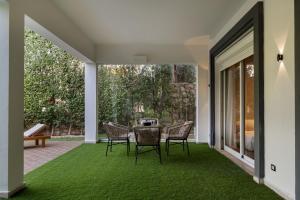a patio with a table and chairs on a green carpet at Zyra villa with pool and waterfall in New Cairo in Cairo