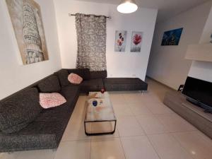 a living room with a couch and a coffee table at St Julians Sliema 3 minutes walk from promenade 3 bedroom apartment in Sliema