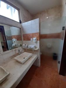 baño con lavabo y espejo grande en HOTEL A´PONTE, en Mérida