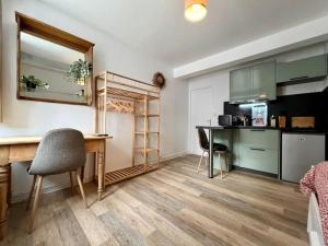 uma cozinha com uma secretária e uma mesa com cadeiras em Appartement 2 prsn / Proche Centre-Ville em Besançon