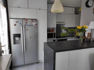 a white kitchen with a refrigerator and a counter at T3 PRADO St-GINIEZ in Marseille