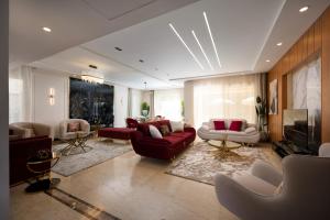 uma sala de estar com sofás vermelhos e uma televisão em Zyra Luxury villa with pool and Jacuzzi in New Cairo no Cairo