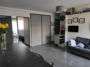 ein Wohnzimmer mit einem Tisch und einem Sofa in der Unterkunft T3 PRADO St-GINIEZ in Marseille