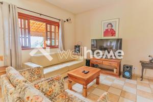 ein Wohnzimmer mit einem Sofa und einem TV in der Unterkunft Casa com banheira, piscina e lareira em Mairinque in Mairinque