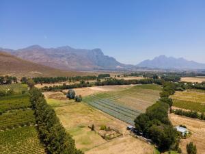 une vue aérienne sur une ferme avec des montagnes en arrière-plan dans l'établissement Franschhoek Cottages, à Franschhoek