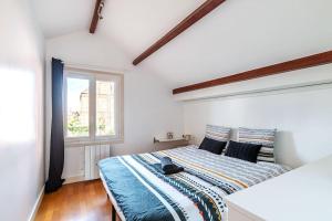 1 dormitorio con cama con sábanas azules y ventana en Cosy Revy - Proche Paris, en Saint-Michel-sur-Orge