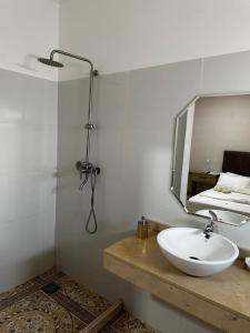 bagno con lavandino, doccia e specchio di CONVENIO RESIDENCIAL a Luanda