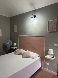 トリノにあるBnB Sakura Via Napioneのベッドルーム1室(ベッド1台、壁に照明付)