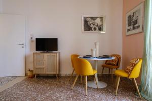 een kamer met een tafel en stoelen en een televisie bij La Golden View in Vieste