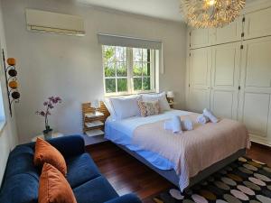 a bedroom with a bed and a blue couch at Charming Villa Jarros Private pool & Golf in Aroeira +89 photos