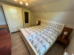 1 dormitorio con 1 cama con edredón blanco en Auszeit!, en Büdelsdorf