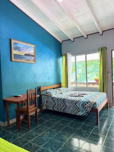 a bedroom with a bed and a table and a window at Hotel El Chaman in Uvita +72 photos