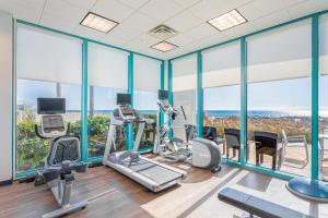 a gym with treadmills and ellipticals and windows at Holiday Inn Express Pensacola Beach, an IHG Hotel in Pensacola Beach