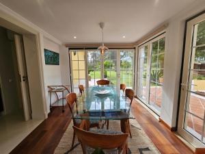 a dining room with a glass table and chairs at Charming Villa Jarros Private pool & Golf in Aroeira
