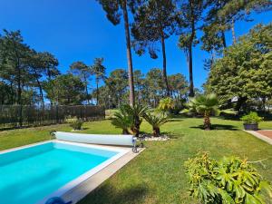 a swimming pool in a yard with trees at Charming Villa Jarros Private pool & Golf in Aroeira