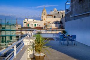 un balcon avec des chaises et des tables sur un immeuble dans l'établissement La Golden View, à Vieste