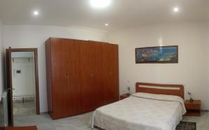 een slaapkamer met een bed en een houten kast bij Sogno di Olena in La Spezia