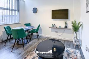 uma sala de estar com uma mesa e cadeiras verdes em Stylish Ensuite Room - Superfast Wi-fi 250mbps em Manchester