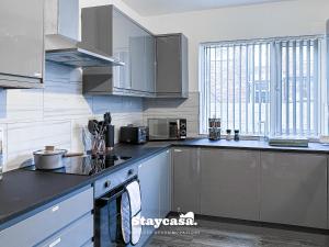 曼徹斯特的住宿－Stylish Ensuite Room - Superfast Wi-fi 250mbps，一个带不锈钢用具的厨房和一个大窗户