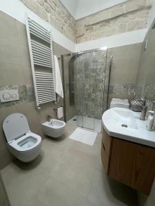 a bathroom with a toilet and a sink and a shower at Home Civico 44 in Ceglie Messapica +5 photos