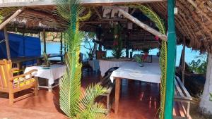 a restaurant with two tables and a palm tree at Piscine bimoko in Nosy Be