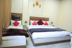 a bedroom with two beds with red pillows at Seth Residency near Golden Temple in Amritsar