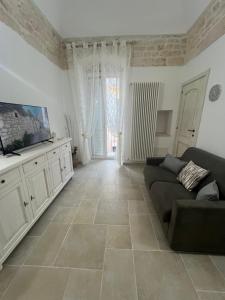 a living room with a couch and a tv at Home Civico 44 in Ceglie Messapica