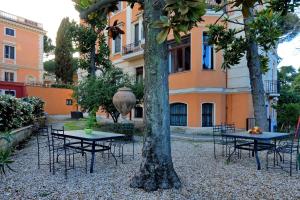 a group of tables and chairs in front of a building at Domus Monamì Apartment in Rome