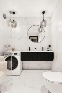 a white bathroom with a washing machine and a mirror at Bryggen // Fløyen Apartments in Bergen