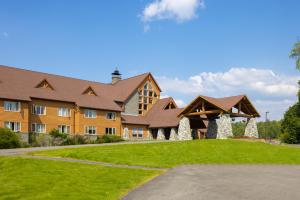 a large building with a green lawn in front of it at Talkeetna Alaskan Lodge in Talkeetna