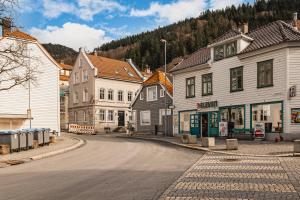 an empty street in a town with buildings and a mountain at Bryggen // Fløyen Apartments in Bergen