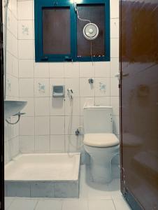 uma casa de banho com um chuveiro, um WC e um lavatório. em Hostel Friends Dubai no Dubai