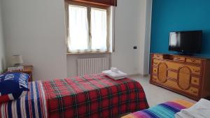 a bedroom with two beds and a tv on a dresser at La Tana della Volpe in Tempera