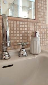 lavabo con grifo cromado y espejo en La casa del Mago camere e appartamenti en Pissignano