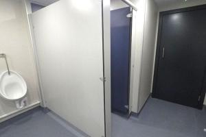 an empty bathroom with a urinal and a door at Campsie Glen Holiday Park in Glasgow